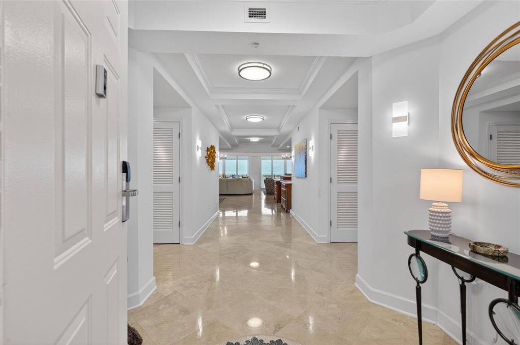 A bright entryway leads down a long hallway with tile floors toward a living area — 200 OCEAN CREST DRIVE UNIT 812, PALM COAST, FL