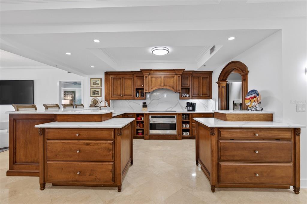A kitchen features wooden cabinetry, white countertops, two islands, and light-colored tile flooring — 200 OCEAN CREST DRIVE UNIT 812, PALM COAST, FL