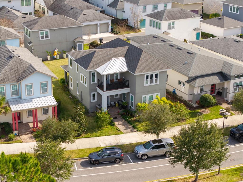 An aerial view shows a two-story gray house with a balcony and a metal roof — 8266 NEMOURS PARKWAY, ORLANDO, FL