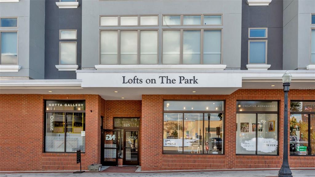The exterior of a brick building features a sign reading Lofts on The Park — 125 N KENTUCKY AVENUE UNIT 501 & 503, LAKELAND, FL