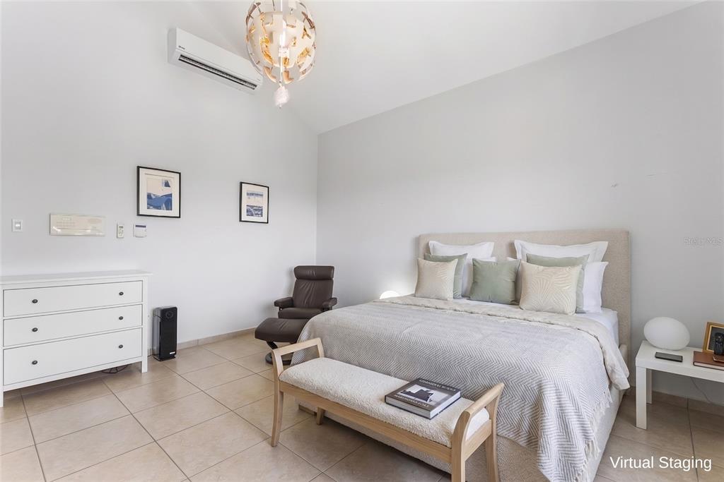 A bedroom with a bed, white dresser, armchair, and tile flooring features a vaulted ceiling — 76 HARBOUR LIGHTS DR, HUMACAO, PR