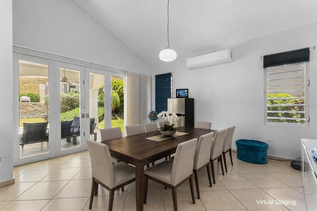 A dining room with a wooden table, eight chairs, tile floors, and glass patio doors — 76 HARBOUR LIGHTS DR, HUMACAO, PR