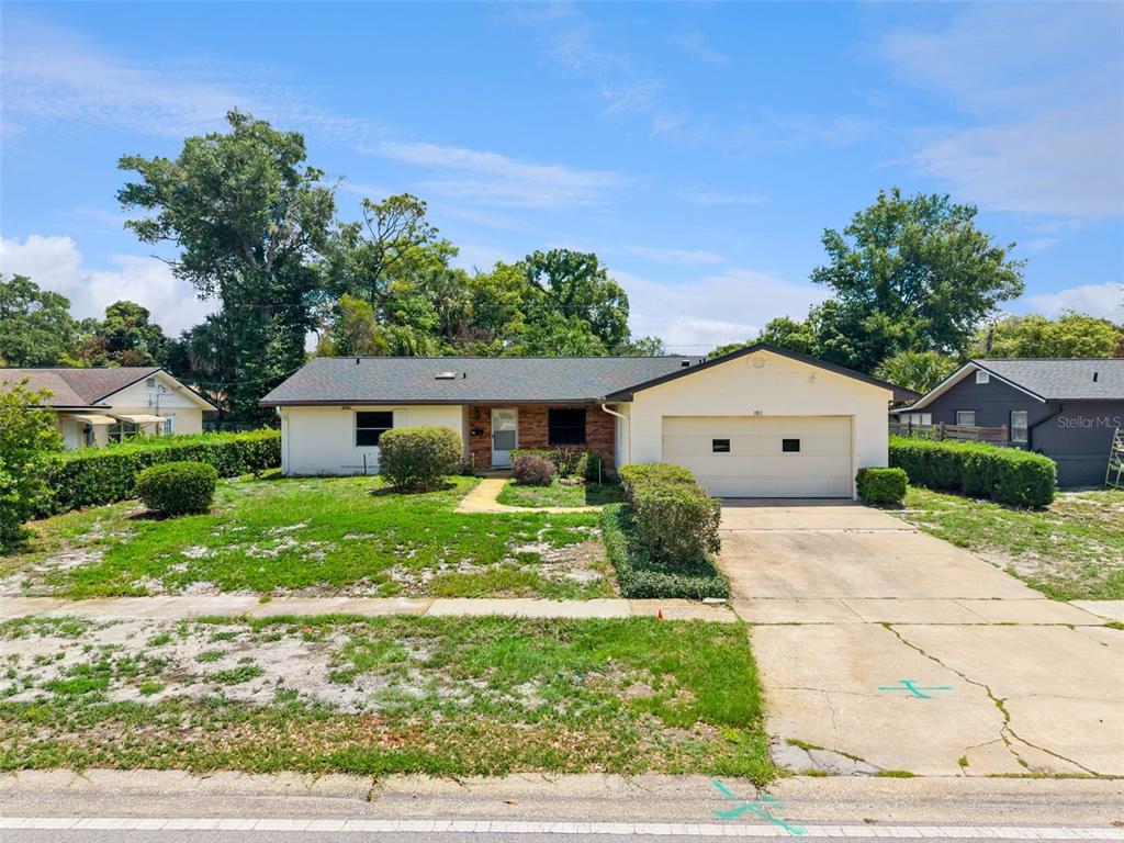 A single-story house with a white exterior, brick accents, and an attached two-car garage — 2512 EASTBROOK BOULEVARD, WINTER PARK, FL