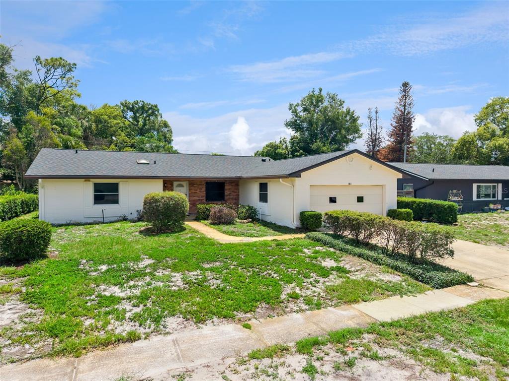 A single-story house with a light-colored exterior, a brick accent wall, and an attached garage — 2512 EASTBROOK BOULEVARD, WINTER PARK, FL