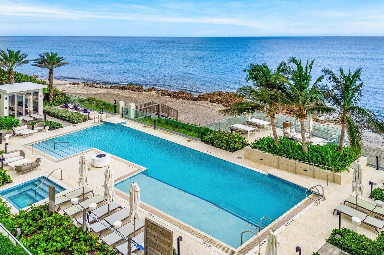 An aerial view of a rectangular swimming pool overlooking the ocean with lounge chairs nearby — 1500 S Beach Road # 301, Tequesta FL 33469, TEQUESTA, FL
