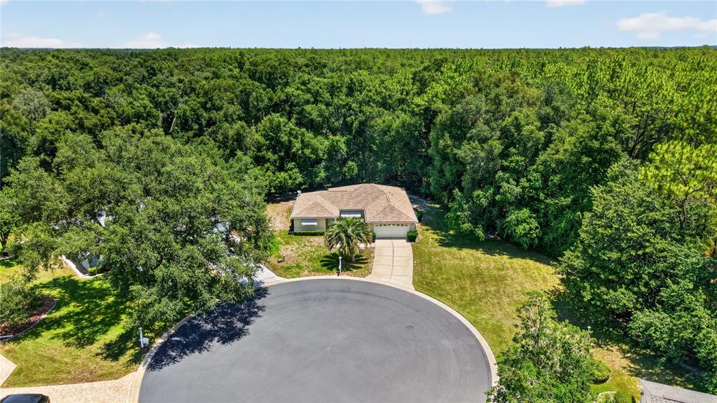 An aerial view shows a single-story house with a driveway situated in a cul-de-sac — 15024 SW 112TH CIRCLE, DUNNELLON, FL