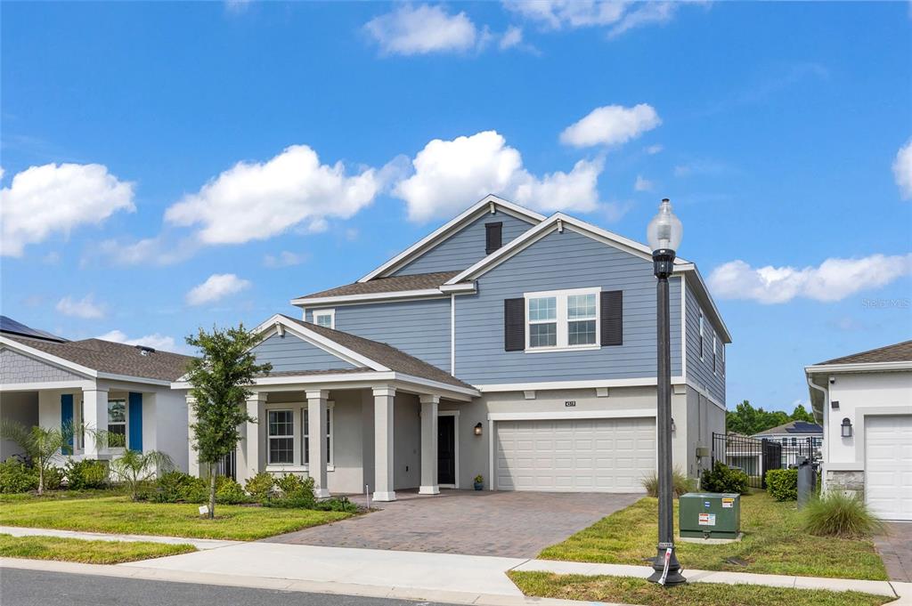 A two-story blue and beige house with a front porch and a two-car garage — 4519 HILLINGDAM ROAD, DAVENPORT, FL