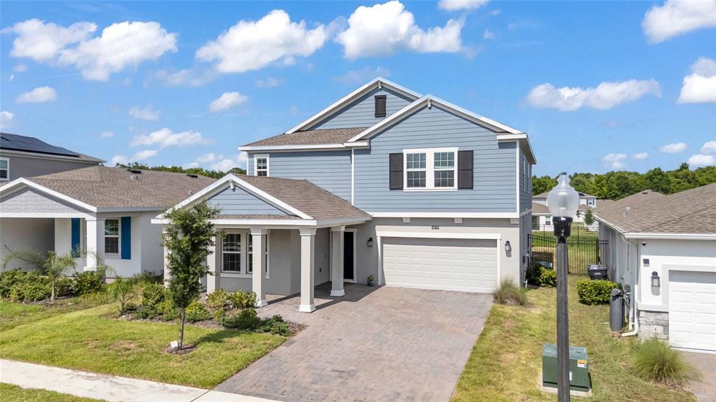 A two-story blue house with a covered porch, a two-car garage, and a paved driveway — 4519 HILLINGDAM ROAD, DAVENPORT, FL