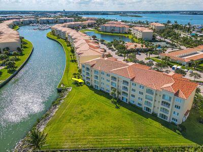 An aerial view shows a multi-story residential building with a red tile roof near water — 4 Harbour Isle Drive E # 106, Fort Pierce FL 34949, FORT PIERCE, FL