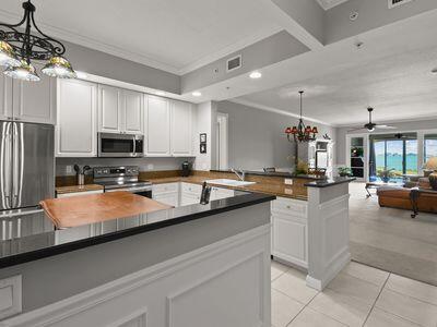 A kitchen with white cabinets, dark countertops, and a view into a living area — 4 Harbour Isle Drive E # 106, Fort Pierce FL 34949, FORT PIERCE, FL