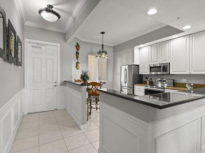 A kitchen with white cabinets, stainless steel appliances, and a breakfast bar area — 4 Harbour Isle Drive E # 106, Fort Pierce FL 34949, FORT PIERCE, FL