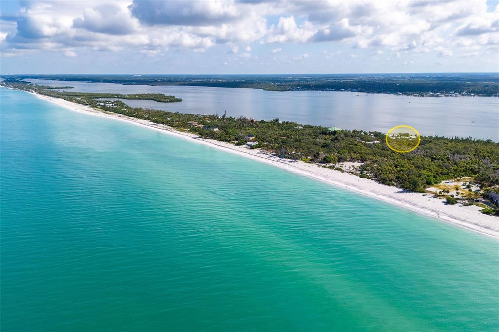 An aerial view shows a sandy beach along turquoise water with a circled property inland — 6275 MANASOTA KEY ROAD, ENGLEWOOD, FL