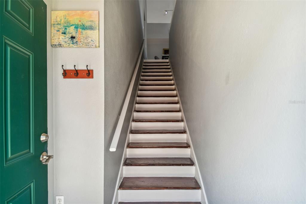 A staircase with dark wood treads and white risers leads upward from an entryway — 10462 WHITE LAKE COURT, TAMPA, FL