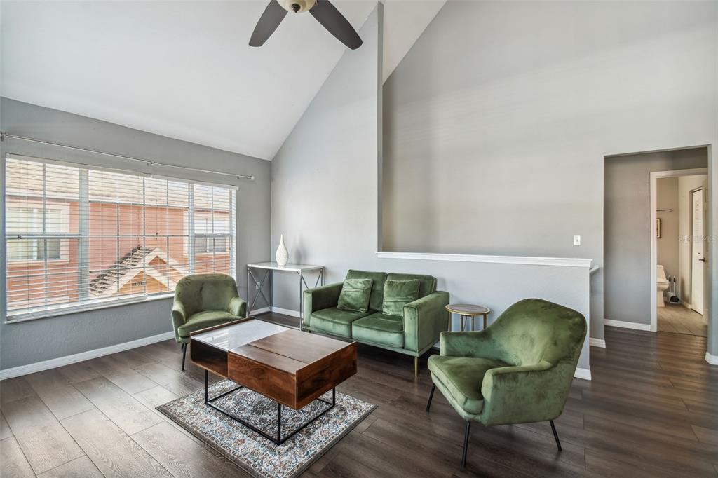 A living room features green velvet furniture, a wooden coffee table, and high vaulted ceilings — 10462 WHITE LAKE COURT, TAMPA, FL