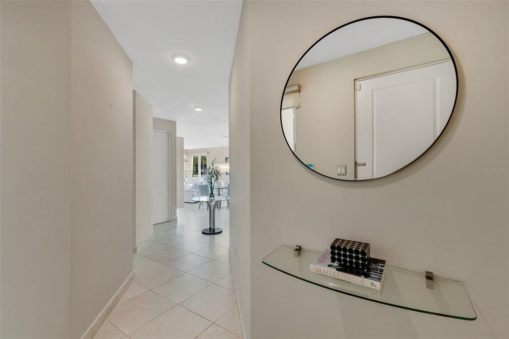 A hallway features a glass wall-mounted shelf, a round mirror, and tile flooring — 6690 CALLE TURQUOISE UNIT 324, VEGA ALTA, PR
