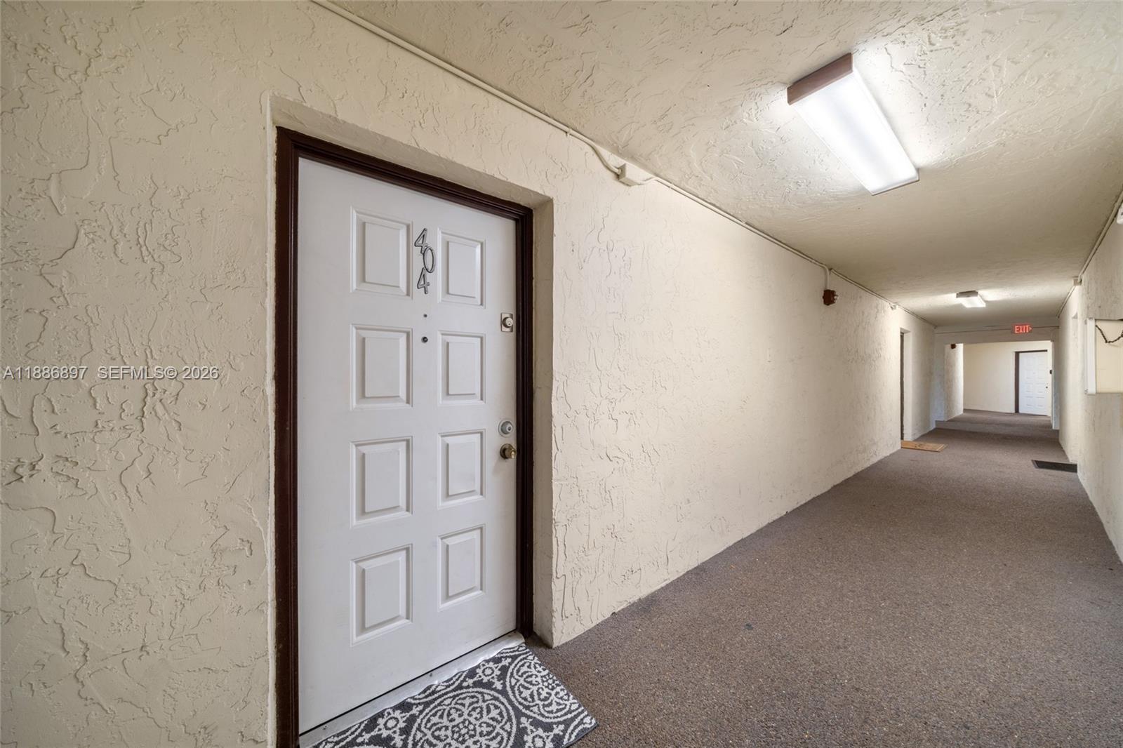 A white apartment door with the number 404 is located in a carpeted hallway — 8005 Lake Dr # 404, Doral FL 33166, DORAL, FL