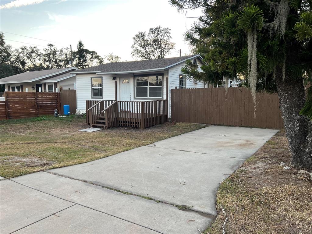 A small white house with a wooden deck and a concrete driveway — 1658 HEMPEL AVENUE, GOTHA, FL