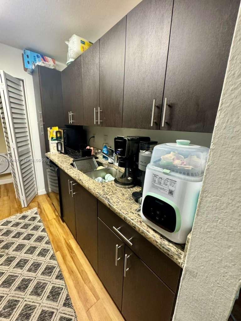 A kitchen features dark wood cabinets, granite countertops, a sink, and various small appliances — 3979 NW 87th Ave # 3979, Sunrise FL 33351, SUNRISE, FL