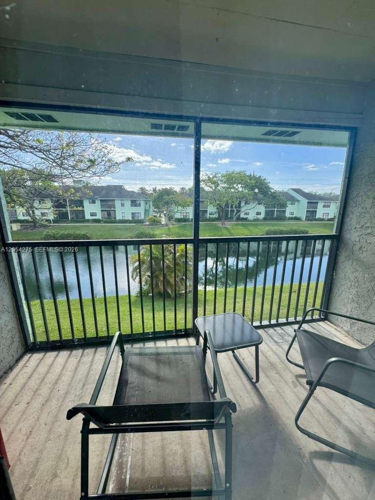 A screened-in balcony overlooks a lake and residential buildings — 3979 NW 87th Ave # 3979, Sunrise FL 33351, SUNRISE, FL