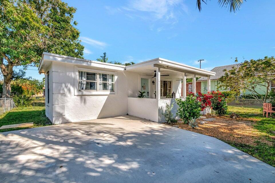 A white single-story house features a concrete driveway, a covered front porch, and landscaping — 237 SW 3rd Avenue, Delray Beach FL 33444, DELRAY BEACH, FL