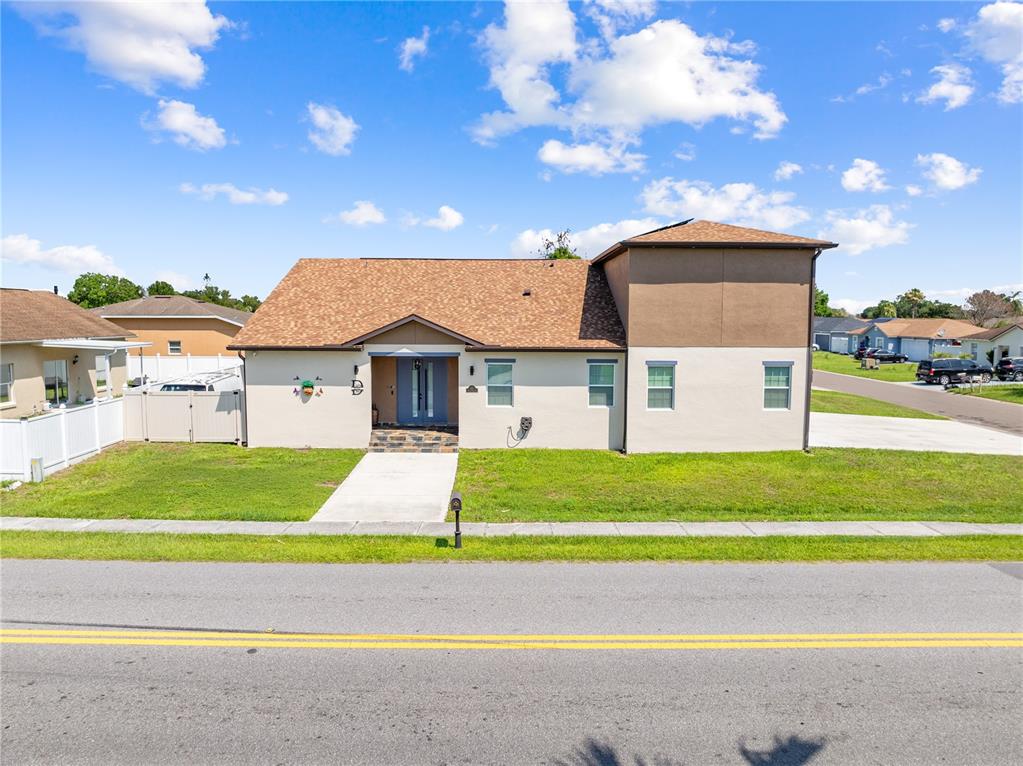 A two-story house with a tan stucco exterior and a brown shingled roof — 501 ROYAL PALM DRIVE, KISSIMMEE, FL