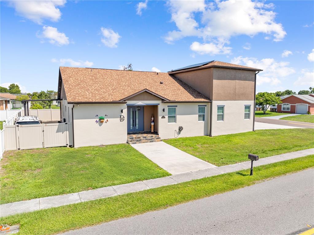 A tan, two-story house with a brown shingled roof and a front concrete walkway — 501 ROYAL PALM DRIVE, KISSIMMEE, FL