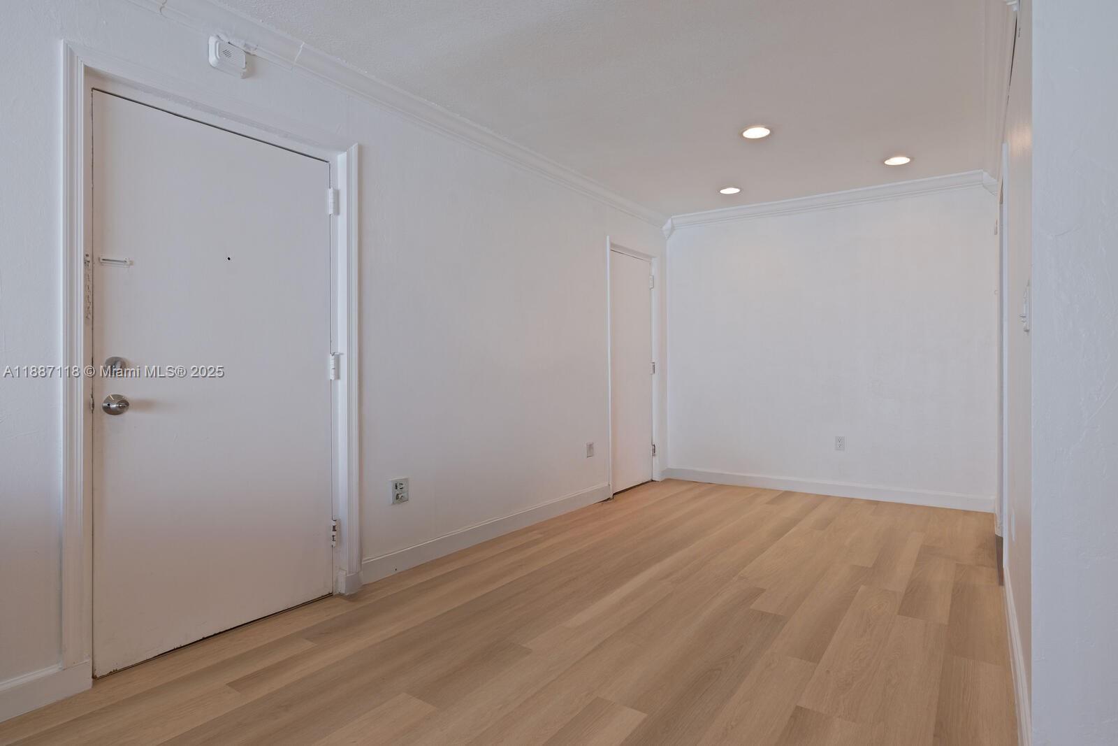 An empty room features white walls, light wood-look flooring, and recessed ceiling lighting — 10816 N Kendall Dr # R16, Miami FL 33176, MIAMI, FL