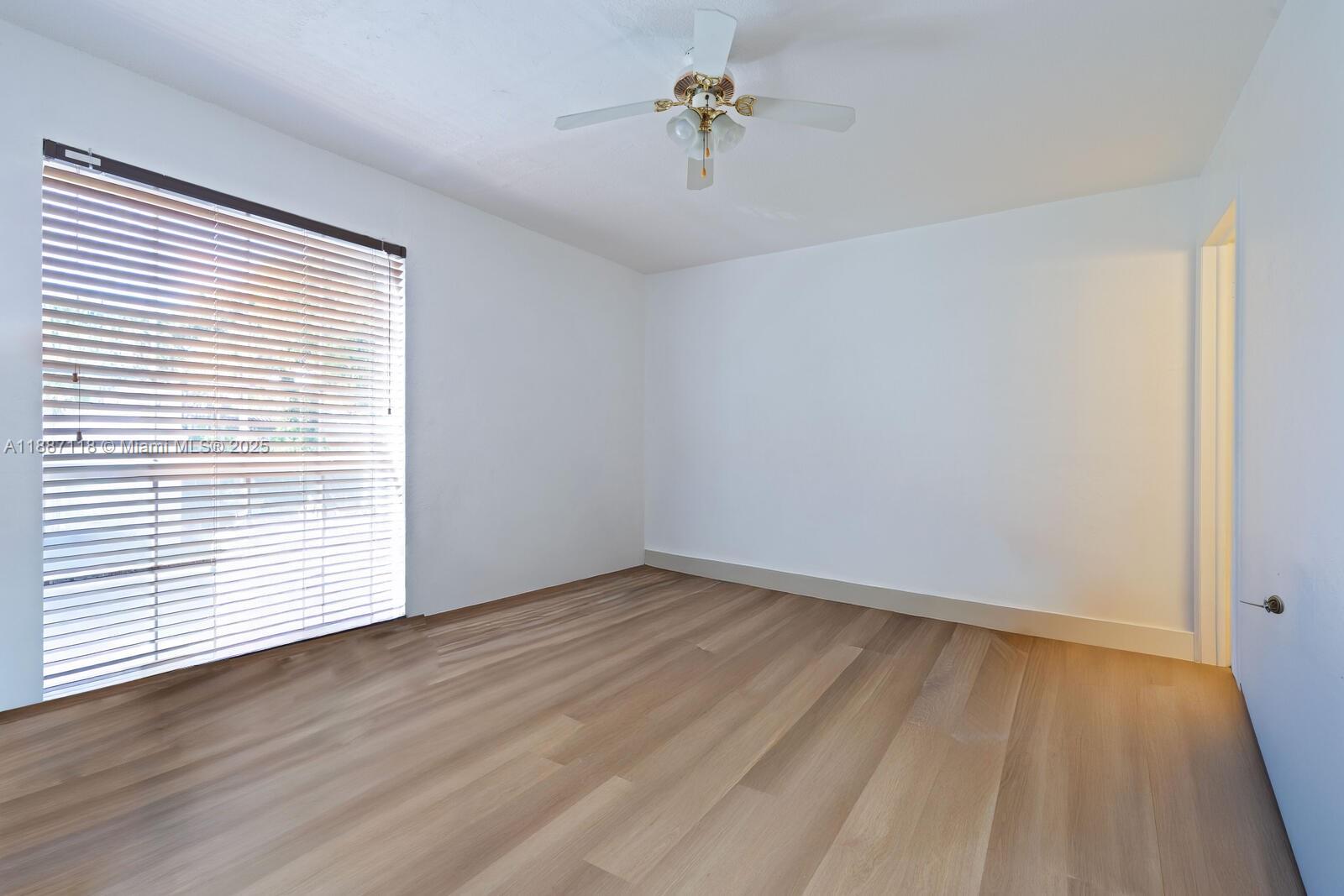 An empty room features light wood flooring, white walls, a ceiling fan, and window blinds — 10816 N Kendall Dr # R16, Miami FL 33176, MIAMI, FL