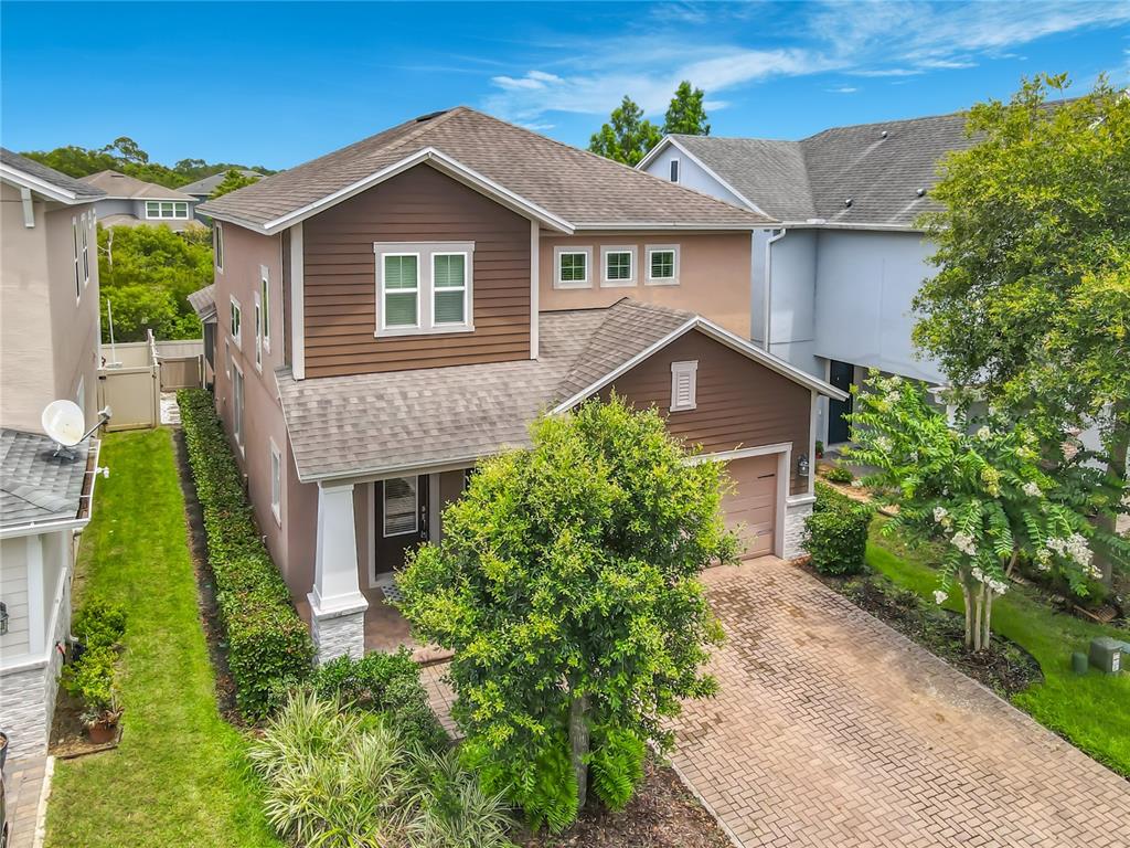 An aerial view of a two-story suburban house with brown siding and a brick driveway — 450 WINDY PINE WAY, OVIEDO, FL