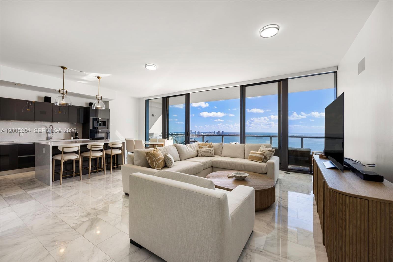 A modern open-concept living room and kitchen feature marble floors and floor-to-ceiling ocean views — 1451 Brickell Ave # 4002, Miami FL 33131, MIAMI, FL
