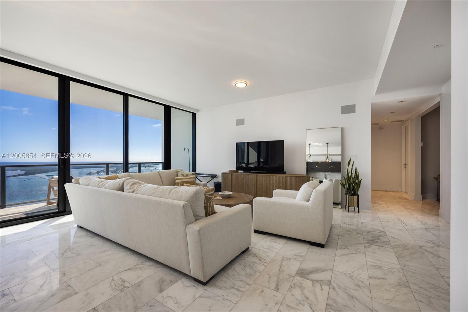 A modern living room features marble floors, a large sectional sofa, and floor-to-ceiling windows — 1451 Brickell Ave # 4002, Miami FL 33131, MIAMI, FL