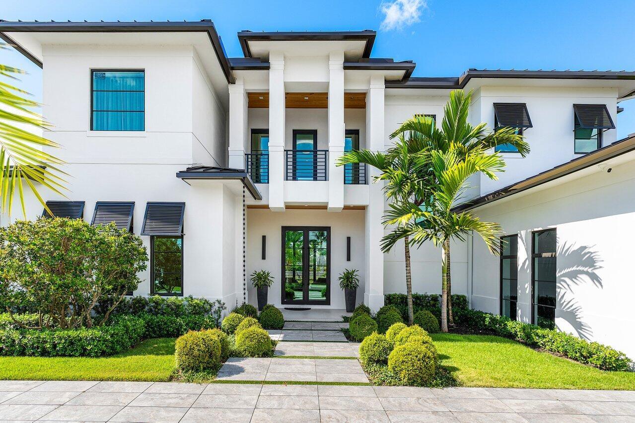A modern two-story white house with a central balcony, dark window frames, and landscaped lawn — 830 Lake Shore Drive, Delray Beach FL 33444, DELRAY BEACH, FL