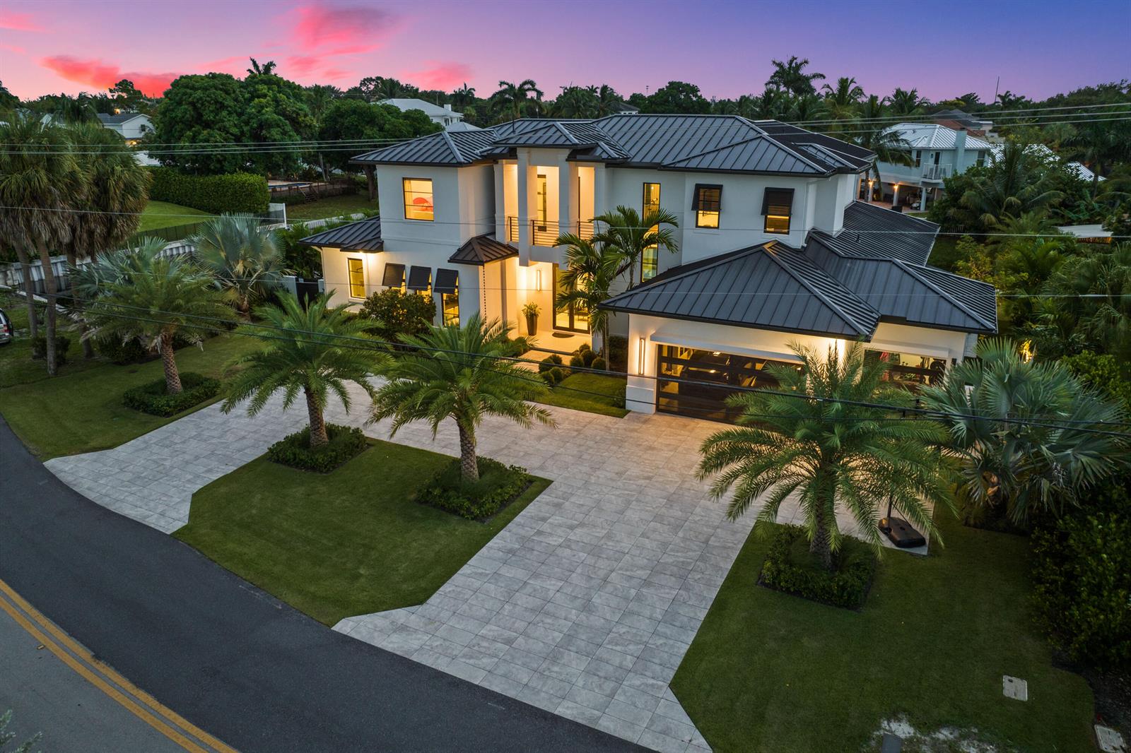 An aerial view of a two-story modern house with a metal roof and paved driveway — 830 Lake Shore Drive, Delray Beach FL 33444, DELRAY BEACH, FL