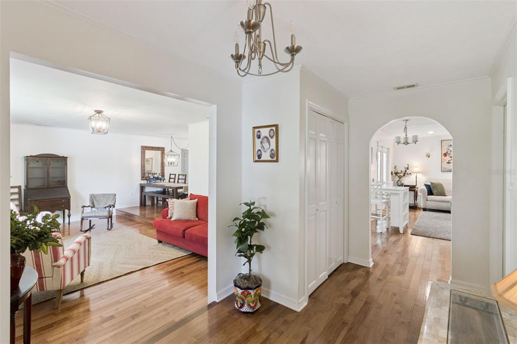 A bright entryway with hardwood floors leads to a living room and a dining area — 204 BIRCH LANE, LAKELAND, FL