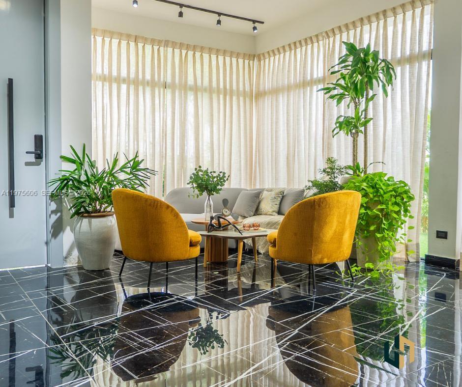 A modern living room features yellow armchairs, a gray sofa, and black marble floors — Las Canas La Estancia Golf and Country Club, DR, DR