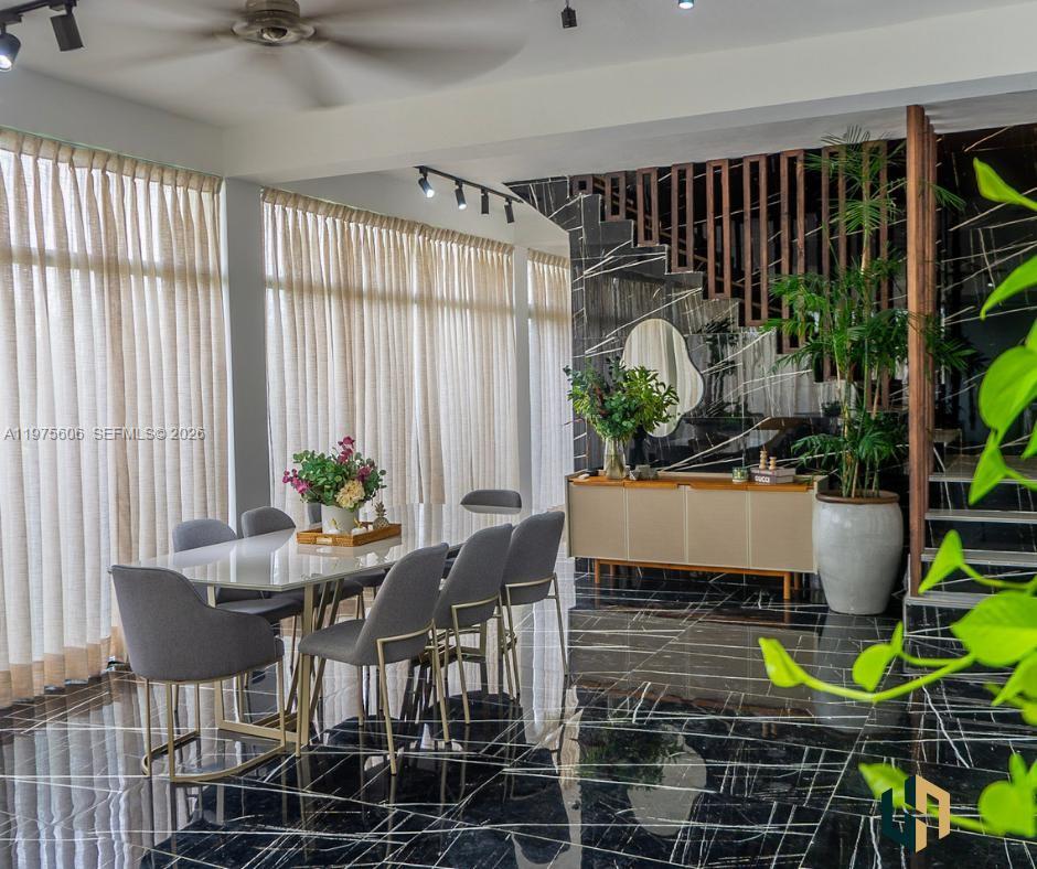 A dining room features a glass table, grey chairs, and black marble floors with veining — Las Canas La Estancia Golf and Country Club, DR, DR