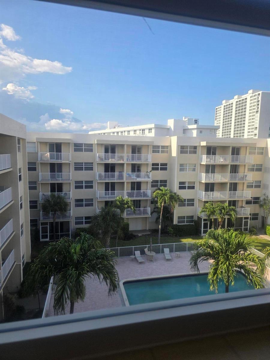 An elevated view of a swimming pool and palm trees between two apartment buildings — 2929 S Ocean Boulevard # 5060, Boca Raton FL 33432, BOCA RATON, FL