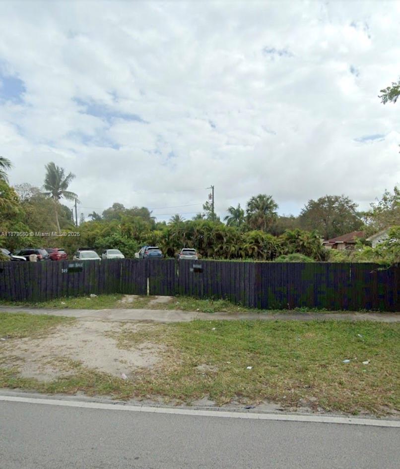 A fenced, grassy vacant lot with several parked cars visible behind the fence — 15505 N Miami Ave, Miami FL 33169, MIAMI, FL