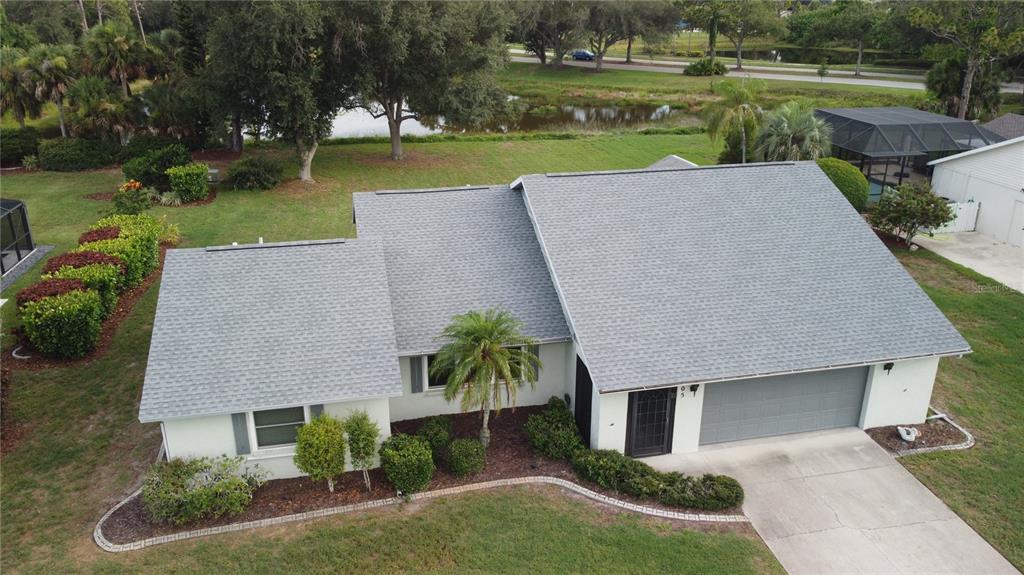 An aerial view of a single-story house with a gray shingled roof and garage — 105 WOODINGHAM DRIVE, VENICE, FL