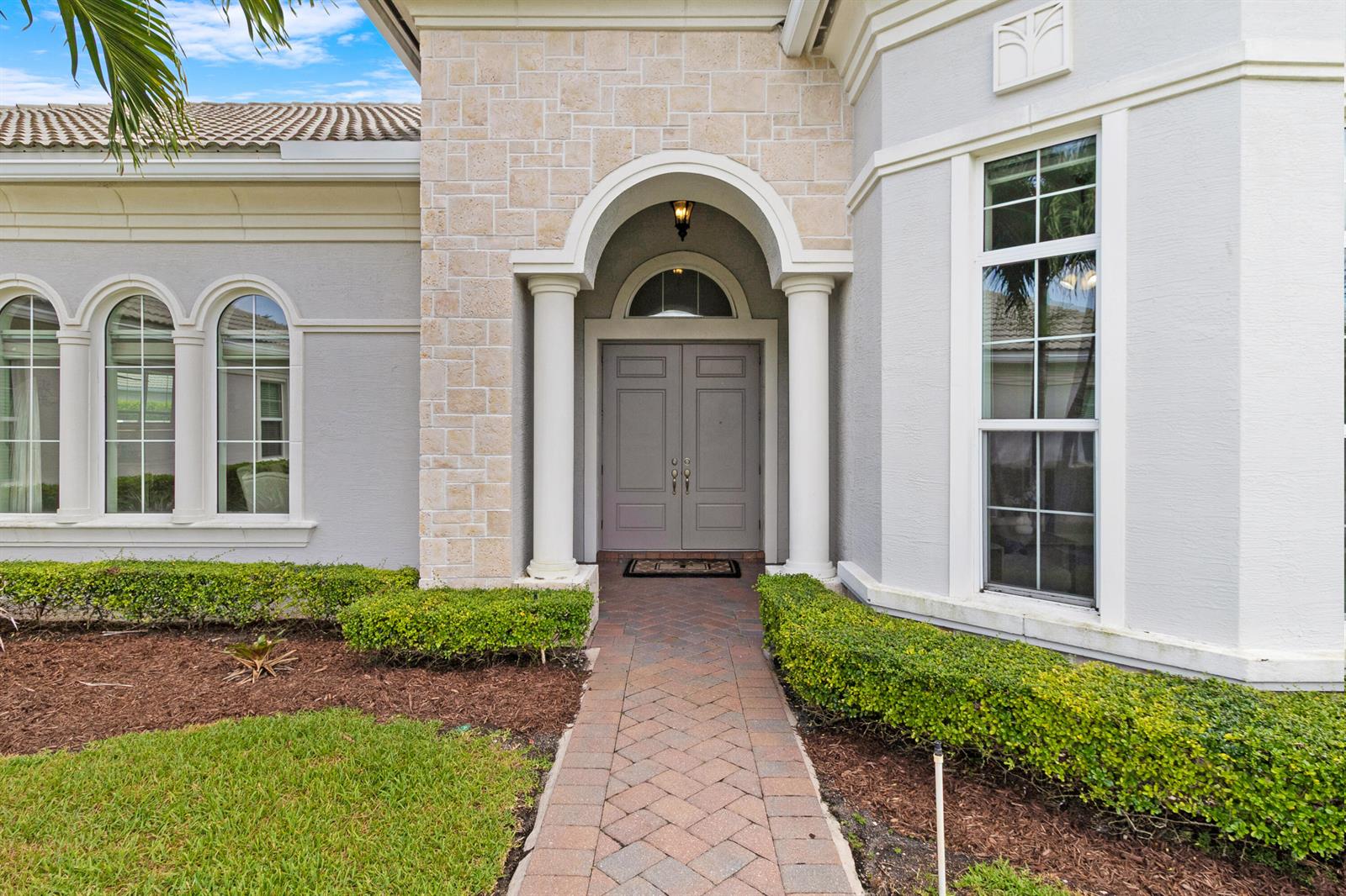A brick walkway leads to the double front doors of a house with stone accents — 4830 W Sterling Ranch Circle, Davie FL 33314, DAVIE, FL