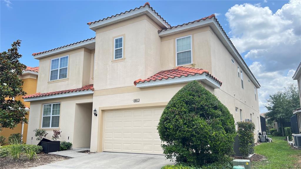 A two-story beige house with a tiled roof and a two-car garage — 6041 BROAD OAK DRIVE, DAVENPORT, FL
