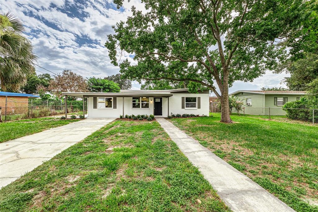 A kitchen with white cabinets, stainless steel appliances, and an island features light wood flooring — 526 VICTORIA BOULEVARD, AUBURNDALE, FL
