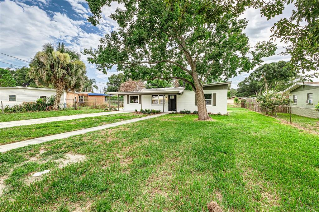 A kitchen features white cabinets, stainless steel appliances, a quartz island, and subway tile backsplash — 526 VICTORIA BOULEVARD, AUBURNDALE, FL
