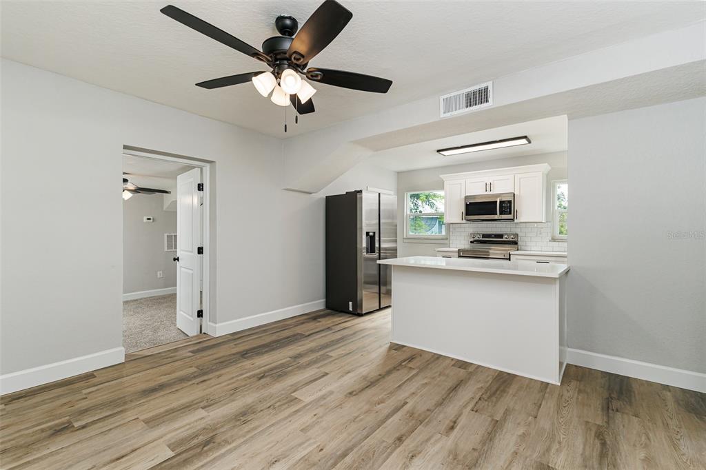A dining area with light gray walls, wood-look flooring, a ceiling fan, and a window — 526 VICTORIA BOULEVARD, AUBURNDALE, FL