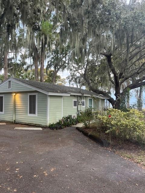A light green, single-story house sits under large trees draped with Spanish moss — 195 MAE STREET UNIT B, EUSTIS, FL
