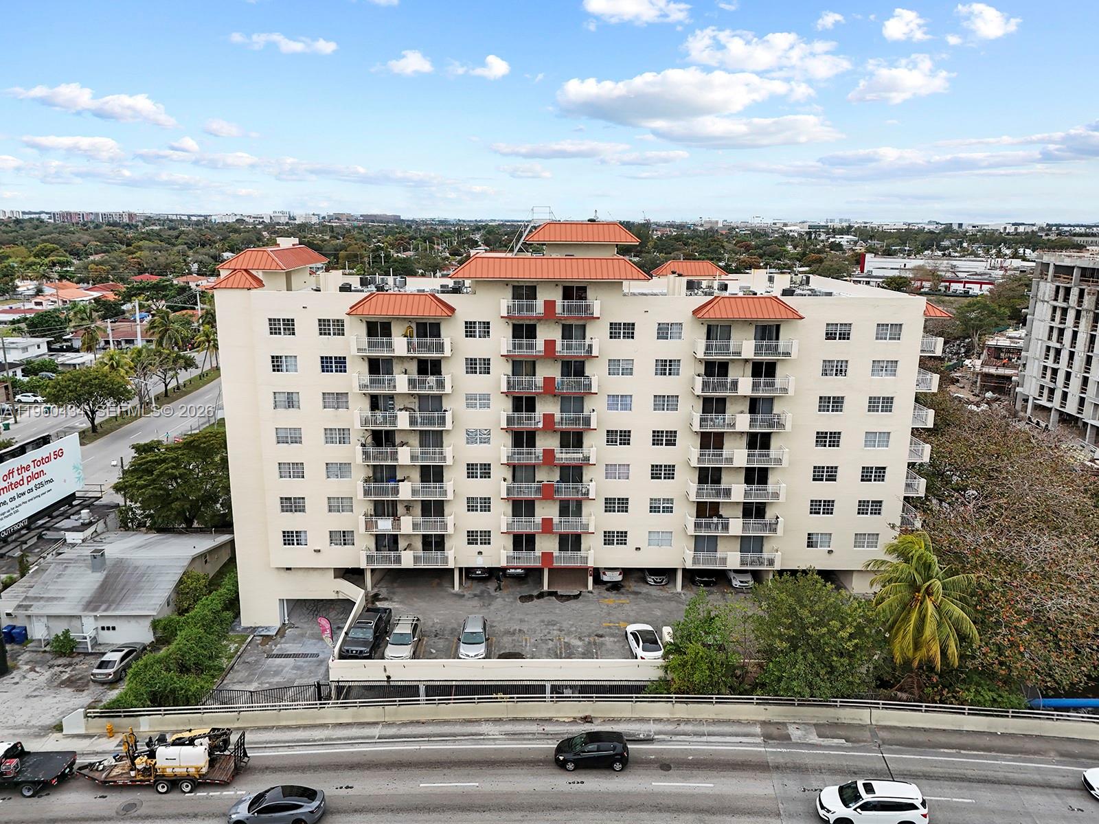An aerial view of a multi-story apartment building with a parking lot and adjacent highway — 1750 NW 27th Ave # 0, Miami FL 33125, MIAMI, FL