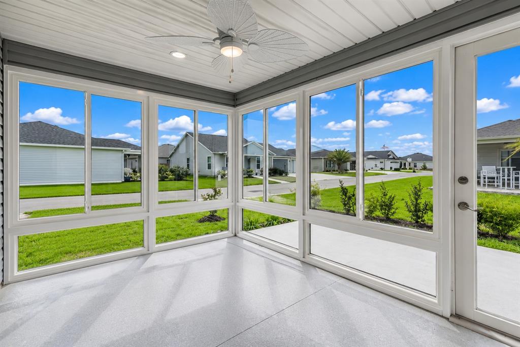 A sunroom with large windows, a ceiling fan, and a light gray epoxy floor — 7462 SAVANNA DRIVE, THE VILLAGES, FL