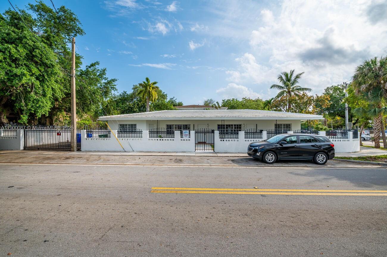 A single-story white building with a fenced front yard and a black car parked outside — 510 NE 66th St # 1, Miami FL 33138, MIAMI, FL