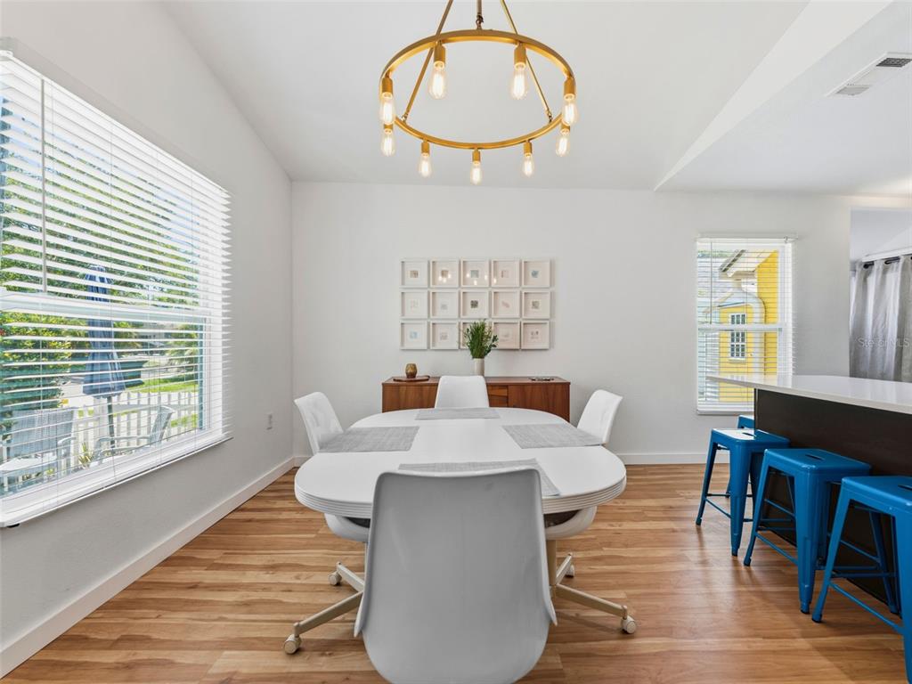 A dining room features a white oval table, modern chairs, a chandelier, and wood flooring — 2005 3RD STREET S, ST PETERSBURG, FL