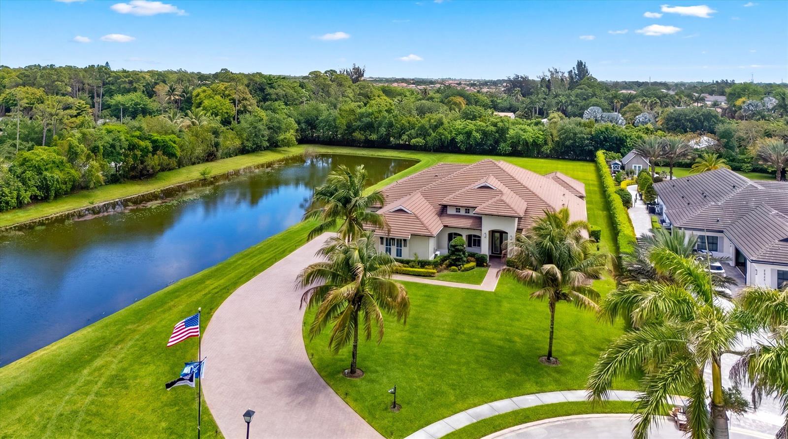 An aerial view shows a house with a tile roof, palm trees, and a pond — 7336 Sisken Terrace, Lake Worth FL 33463, LAKE WORTH, FL